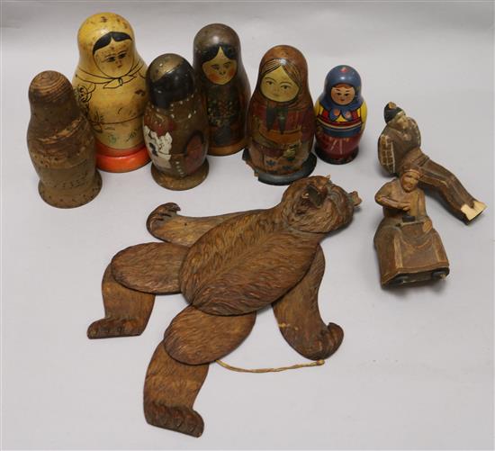 A Black Forest Bear string puppet, various Russian dolls and two carved figures